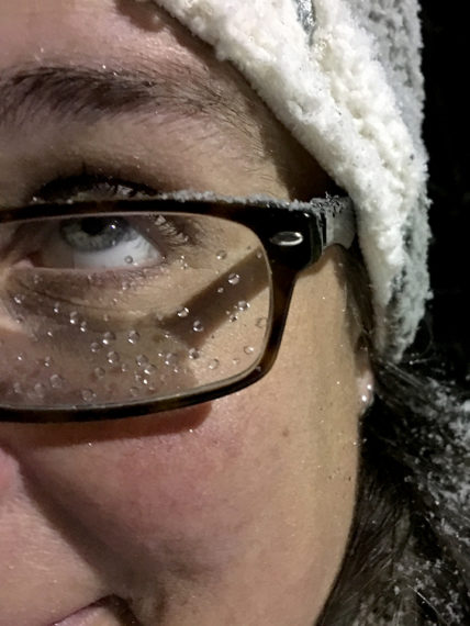 A close up of Season's face showing an eye looking up and her glasses with raindrops on them