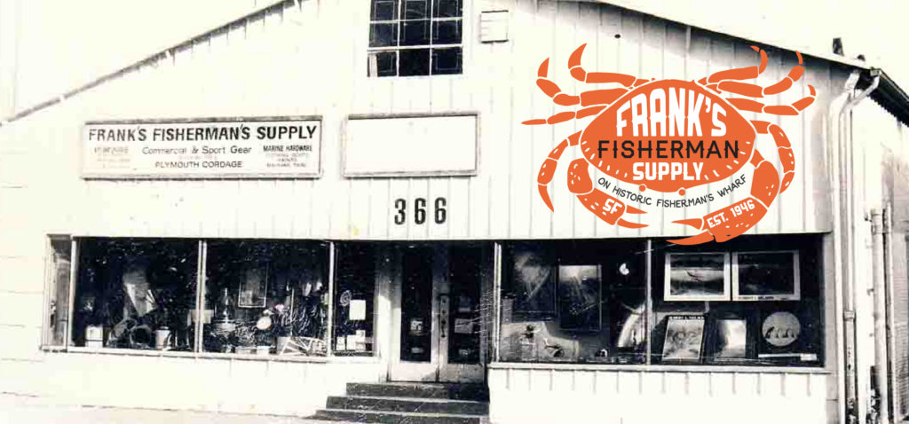 Black and white photo of a storefront with signage reading "Frank's Fisherman's Supply" and a large crab logo on the facade. The building has two large front windows displaying various fishing supplies.